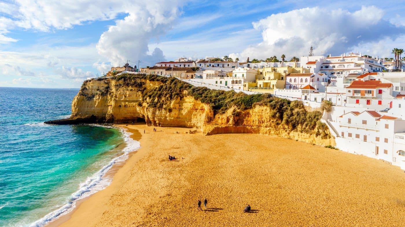 Sandy beach between cliffs and white architecture in Carvoeiro, Algarve, Portugal