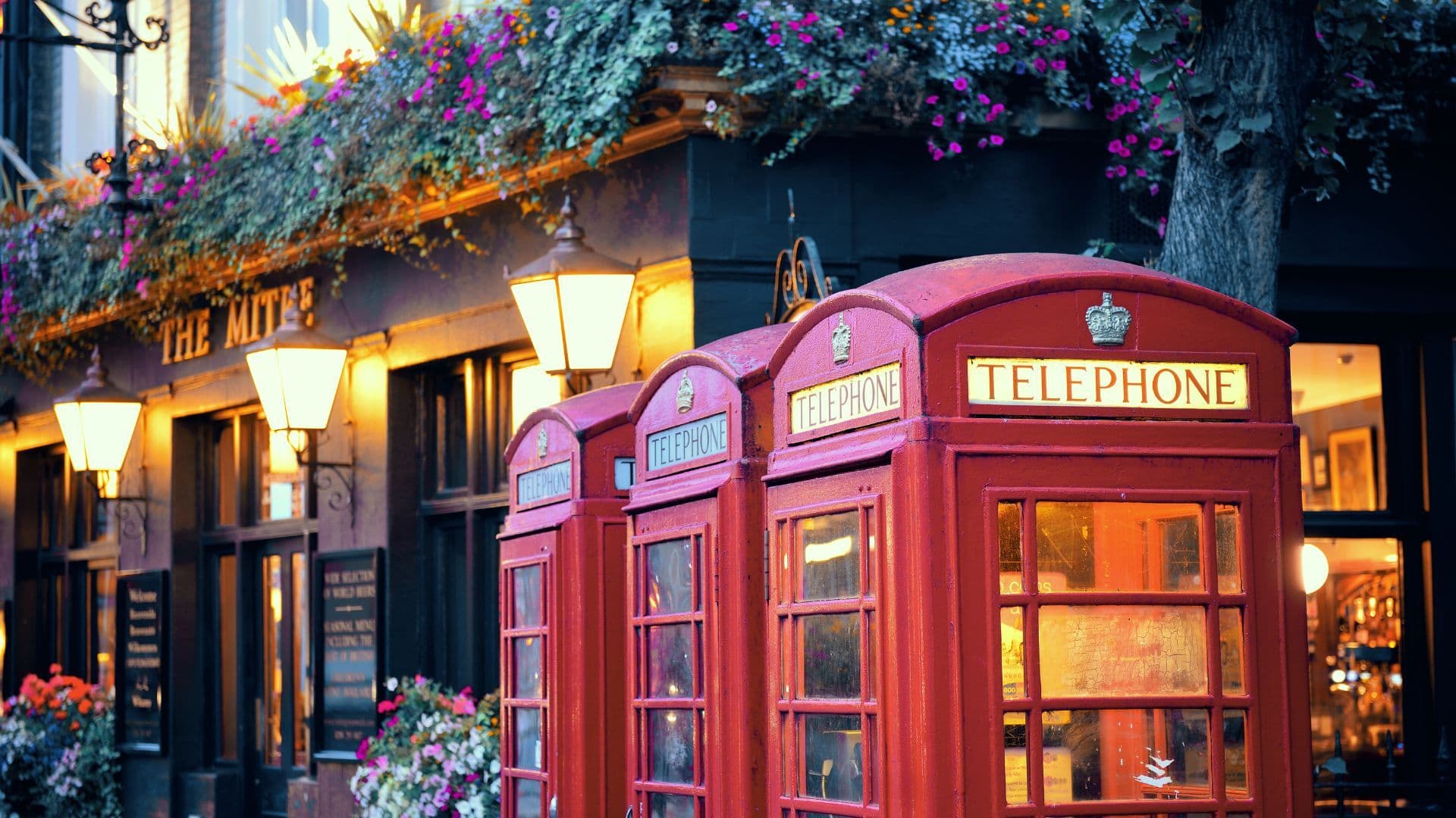 Red phone boxes in front of an English pub