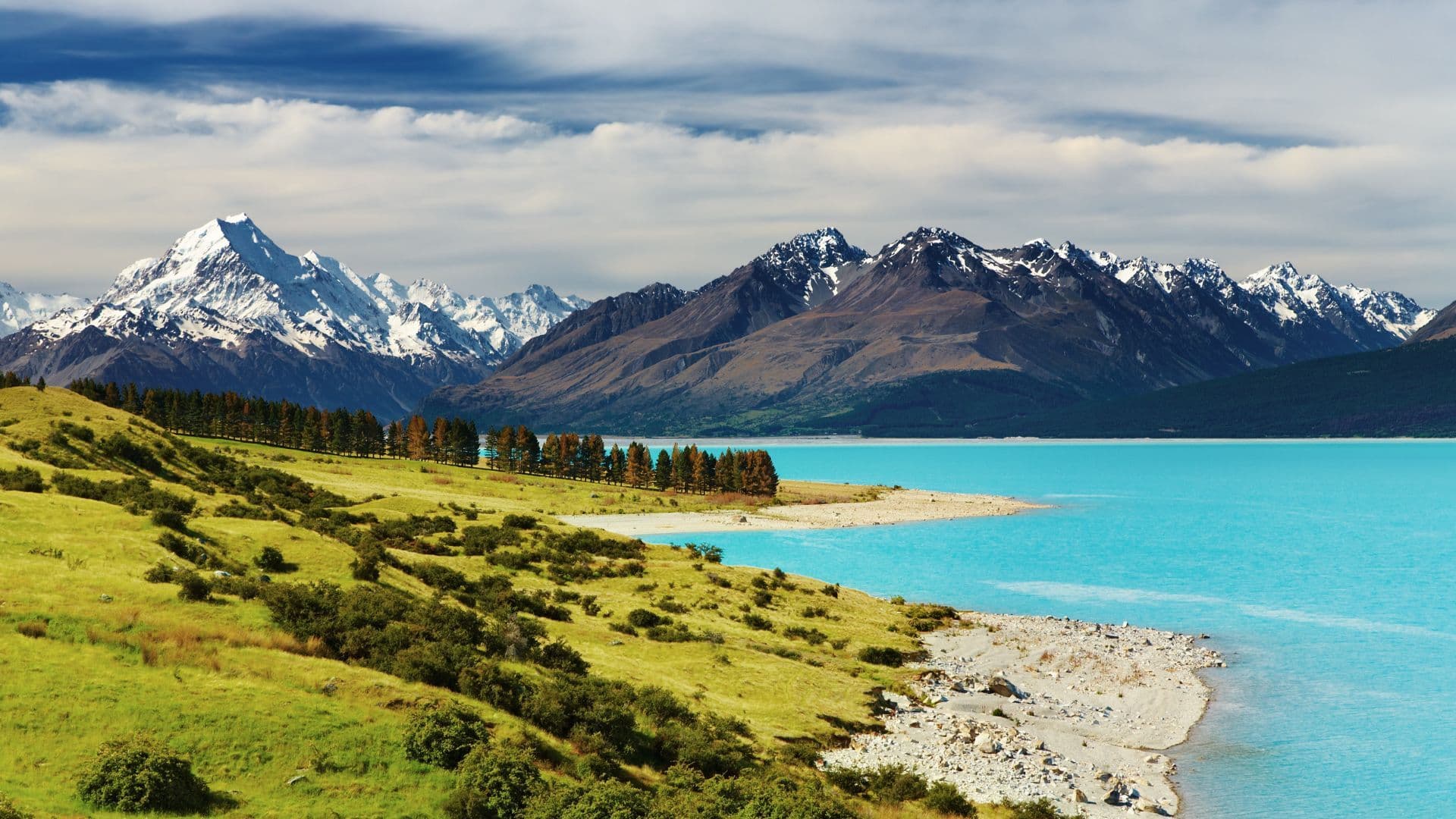 Alpine lake surrounded by snow-capped mountains.